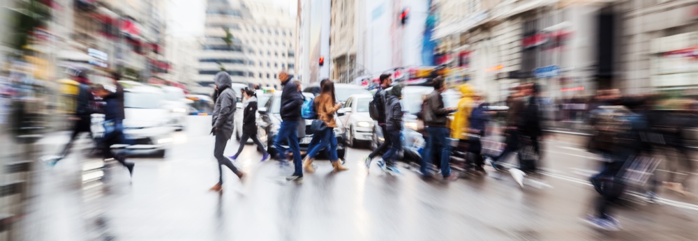 Bild mit Zoomeffekt von Menschen die eine Straße überqueren